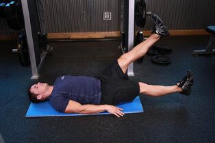 Hombre con prostatitis realiza un ejercicio en el gimnasio. 